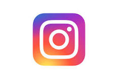 Instagram logo. Purple, pink, orange, and red sunset colors in a square shape with the outline of a camera lens in the middle in white.